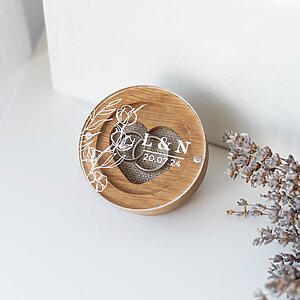 Round Wooden Ring Box with Clear Acrylic Lid, Equipped with Magnets, Decorated with White Floral Engraving, Initials, and Date. Inside — a Heart-Shaped Slot for Wedding Rings and a Linen Cushion.