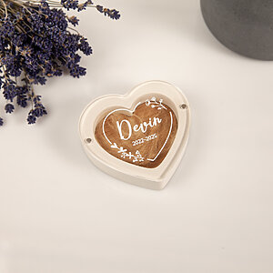 White heart-shaped pet fur keepsake box with custom engraved name Devin, dates, and floral design.