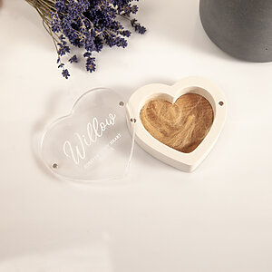 Open heart-shaped pet fur container showing magnetic acrylic lid and dog hair inside.