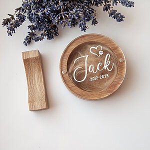 Round oak dog hair keepsake box containing pet fur with the name Jack UV-printed on the clear acrylic lid.