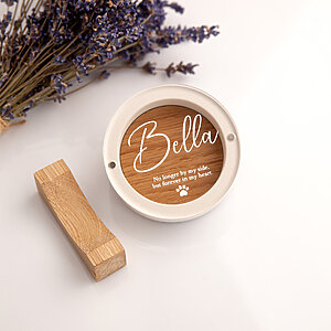 Top-down view of an empty round white plaster pet keepsake box with UV printed acrylic lid and dried lavender.