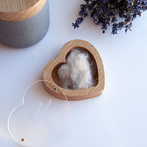 Angled view of a heart shaped oak dog hair keepsake box with a lock of pet fur inside